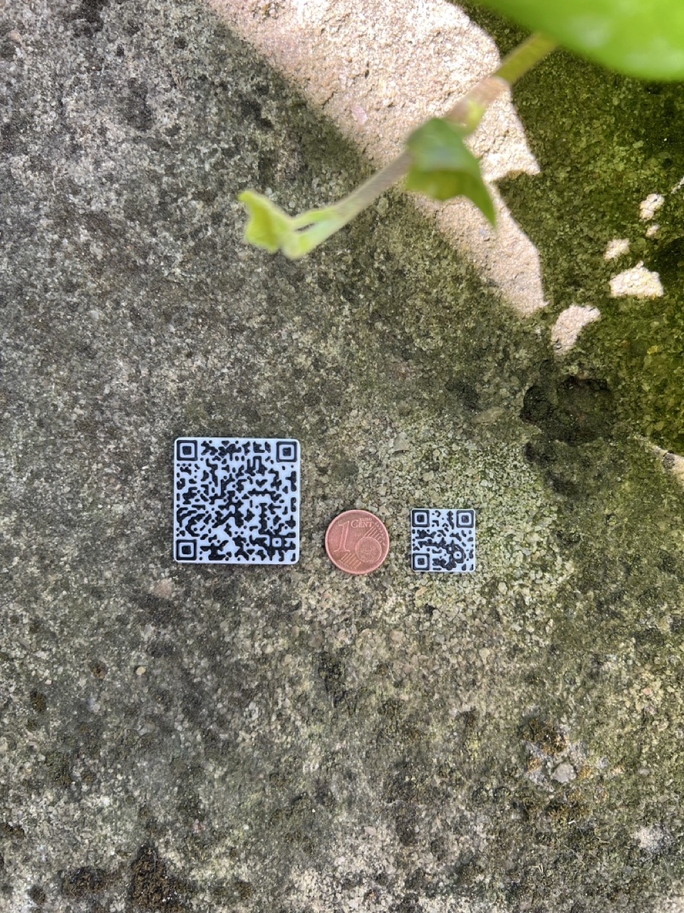 Tiny printed QR code next to a larger QR code and a one-cent coin